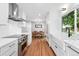 Bright kitchen with white cabinetry, stainless steel appliances, and a view of the dining room at 3380 S Ogden St, Englewood, CO 80113