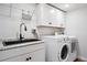Bright laundry room features granite countertops, sink, storage cabinets and a new washer and dryer at 3380 S Ogden St, Englewood, CO 80113