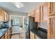 Functional kitchen layout with wooden cabinetry, granite countertops, and stainless steel refrigerator at 1309 Jamaica St, Aurora, CO 80010