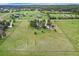 Sprawling property featuring a home, outbuildings, and vast fenced green fields under a blue sky with scattered clouds at 497 Grey Squirrel Way, Franktown, CO 80116