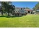 Rear view of a home featuring a spacious deck, well-maintained lawn, and mature trees at 497 Grey Squirrel Way, Franktown, CO 80116