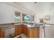Wet bar with granite countertops, stainless steel dishwasher, wooden cabinetry, and large windows at 497 Grey Squirrel Way, Franktown, CO 80116