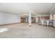 Spacious carpeted basement area featuring a bar with wooden cabinets and barstool seating at 497 Grey Squirrel Way, Franktown, CO 80116