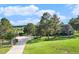 Beautiful home surrounded by mature trees, a long driveway, and lush green lawns at 497 Grey Squirrel Way, Franktown, CO 80116
