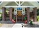 Inviting front porch with brick columns and decorative plants, creating a warm entrance at 497 Grey Squirrel Way, Franktown, CO 80116