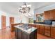 Well-equipped kitchen with a cooktop island, wooden cabinets, and open access to a bright living area at 497 Grey Squirrel Way, Franktown, CO 80116