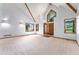 Bright living room with vaulted ceilings, wood beams, neutral carpet, and multiple windows showcasing the outdoor view at 497 Grey Squirrel Way, Franktown, CO 80116