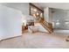 Open-concept living space with staircase, chandelier, and a glimpse into the adjacent kitchen area at 497 Grey Squirrel Way, Franktown, CO 80116