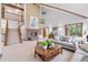 Cozy living room with a brick fireplace, staircase to upper level, and comfortable seating arrangement at 497 Grey Squirrel Way, Franktown, CO 80116