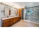 This main bathroom features double sinks, wood cabinets, and a modern walk-in shower at 497 Grey Squirrel Way, Franktown, CO 80116