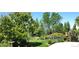 Backyard garden featuring mature trees and flowering bushes on a lush lawn at 22386 E Arbor Pl, Aurora, CO 80016