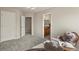 Neutral-toned bedroom with gray carpet, white trim, chair, and adjacent bathroom at 22386 E Arbor Pl, Aurora, CO 80016