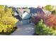 Landscaped two-story home featuring a three-car garage and colorful fall foliage at 22386 E Arbor Pl, Aurora, CO 80016
