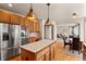 Modern kitchen with stainless steel appliances, center island, and hardwood floors, ideal for culinary enthusiasts at 22386 E Arbor Pl, Aurora, CO 80016