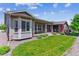 Well maintained lawn featuring covered outdoor living area with brick pillars and manicured landscaping at 22656 E Glidden Dr, Aurora, CO 80016