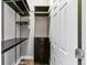 Organized closet featuring dark wood shelving, drawers, and ample storage space at 22656 E Glidden Dr, Aurora, CO 80016