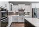 Modern kitchen features white cabinets, stainless appliances and mosaic tile backsplash at 22656 E Glidden Dr, Aurora, CO 80016