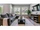 Cozy living room featuring a plush gray sectional, a modern entertainment center, and plantation shutters at 22656 E Glidden Dr, Aurora, CO 80016