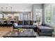View of a well-lit living room featuring a comfortable gray sectional couch, modern lighting, and an open-concept design at 22656 E Glidden Dr, Aurora, CO 80016