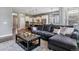 Open-concept living room flows into the kitchen, featuring hardwood floors, modern lighting, and a stylish gray sectional couch at 22656 E Glidden Dr, Aurora, CO 80016