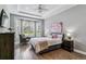 Inviting primary bedroom with a tray ceiling, bay window, hardwood floors, and a plush bed at 22656 E Glidden Dr, Aurora, CO 80016