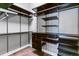 Spacious walk-in closet with custom shelving, dark wood organizers, and hardwood floors at 22656 E Glidden Dr, Aurora, CO 80016