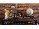 Close-up of the well-stocked bar cart in the living room with exposed brick wall at 2261 Blake St # 5H, Denver, CO 80205