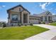 Beautifully landscaped front yard leading up to a charming home with stone facade and welcoming porch at 18926 W 94Th Ave, Arvada, CO 80007