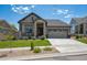 Charming single Gathering home features a manicured lawn, stone accents, and a two car garage at 18926 W 94Th Ave, Arvada, CO 80007