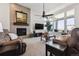 Comfortable living room features a fireplace, ceiling fan, large windows, and relaxing brown couches at 18926 W 94Th Ave, Arvada, CO 80007