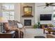 Inviting living room with a tiled fireplace, large windows, plush carpet, and a comfortable sofa at 18926 W 94Th Ave, Arvada, CO 80007