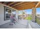 Outdoor patio showcasing exposed wood beam ceiling, brick columns and dual chairs for relaxation at 18926 W 94Th Ave, Arvada, CO 80007