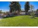 Expansive backyard featuring a privacy fence, mature trees, patio and storage shed at 90 Ammons St, Lakewood, CO 80226