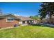 Spacious backyard with lush green grass, patio area, mature tree and shed at 90 Ammons St, Lakewood, CO 80226