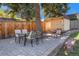 An outdoor seating area with a table and chairs sits beside a storage shed in a well-maintained backyard at 90 Ammons St, Lakewood, CO 80226