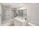 Bright bathroom featuring a dual sink vanity with tiled shower and glass door at 90 Ammons St, Lakewood, CO 80226