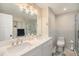 Bathroom showcasing double sinks, a large mirror, and a glass door shower at 90 Ammons St, Lakewood, CO 80226