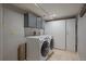 Basement laundry room with full-size washer and dryer, storage cabinets, and tile flooring at 1818 S Quebec Way # B15-5, Denver, CO 80231