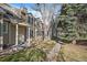 Attractive townhome featuring a green lawn, mature trees, and a welcoming pathway at 1818 S Quebec Way # B15-5, Denver, CO 80231