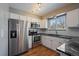 Bright kitchen with stainless steel appliances, granite countertops, and white cabinetry at 1818 S Quebec Way # B15-5, Denver, CO 80231