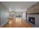 Open-concept living room with hardwood floors, a modern fireplace, and sliding glass doors to the deck at 1818 S Quebec Way # B15-5, Denver, CO 80231
