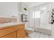 Bright bathroom with white tile flooring, a vanity and shower with a fresh white shower curtain at 1835 Columbine Ave, Boulder, CO 80302