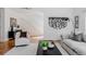 Bright, modern living room featuring hardwood floors, an open staircase, and stylish black and white abstract art at 1835 Columbine Ave, Boulder, CO 80302