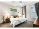Bright bedroom with neutral tones, a large window with green foliage, and stylish mid-century modern furniture at 2103 W 32Nd Ave # 10, Denver, CO 80211