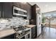 Well-equipped kitchen with stainless steel appliances, mosaic tile backsplash, and dark wood cabinetry at 2103 W 32Nd Ave # 10, Denver, CO 80211