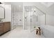 Bright bathroom featuring a glass-enclosed shower, soaking tub, and herringbone tile flooring at 2434 Mapleton Ave, Boulder, CO 80304
