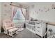 Charming Bedroom with crib, glider, and soft pink floral decor at 16841 Askins Loop # 105, Parker, CO 80134