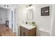 Bathroom with a wood vanity, white countertop, decorative mirror and hallway view at 2393 E 90Th Ave, Thornton, CO 80229