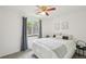 Cozy bedroom with a queen size bed, ceiling fan, and a view to the outside at 2393 E 90Th Ave, Thornton, CO 80229