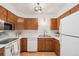 Bright kitchen featuring wood cabinets, stainless steel microwave, white appliances, and a modern faucet at 2393 E 90Th Ave, Thornton, CO 80229